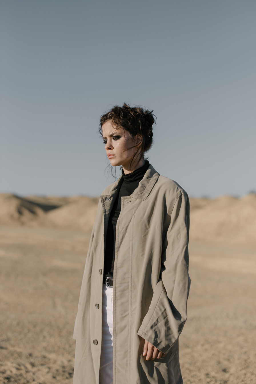 Woman in Brown Coat Standing on Brown Field